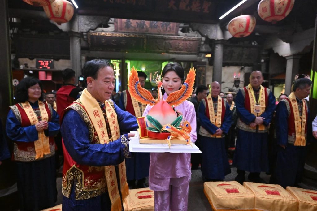 Actress Liu Tao in a purple dress offering a birthday peach to Mazu